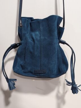 Fossil Blue Suede Bucket Bag with Drawstring Closure And Tassel Details.